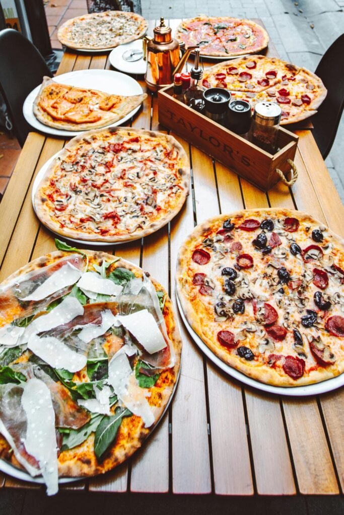 A collection of freshly baked pizzas on a wooden table, perfect for a cozy restaurant setting.